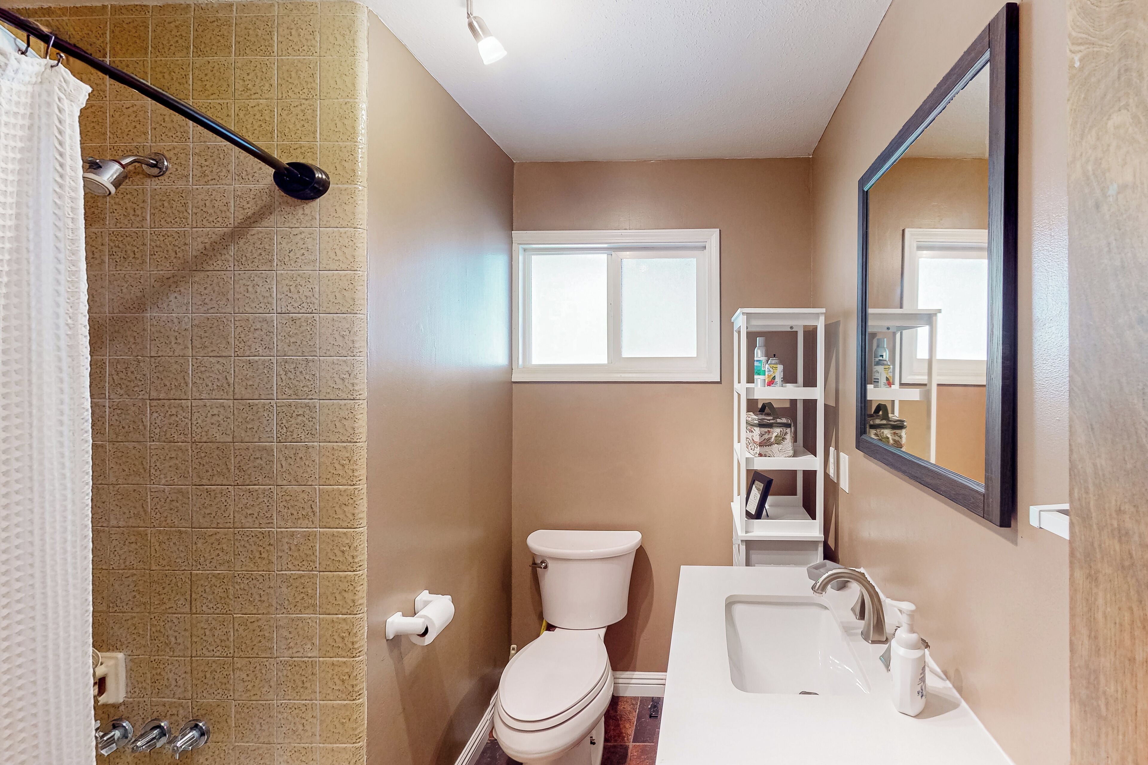 A bathroom with a toilet, sink, and shower.