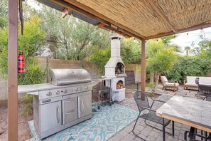 An outdoor kitchen with a grill, oven, and seating area. - Luxurious Outdoor Oasis! Spacious Mesa Retreat (Mesa)