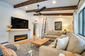 A living room with a fireplace, a sofa set, a coffee table, and a TV mounted on the wall. - Luxurious Outdoor Oasis! Spacious Mesa Retreat (Mesa)