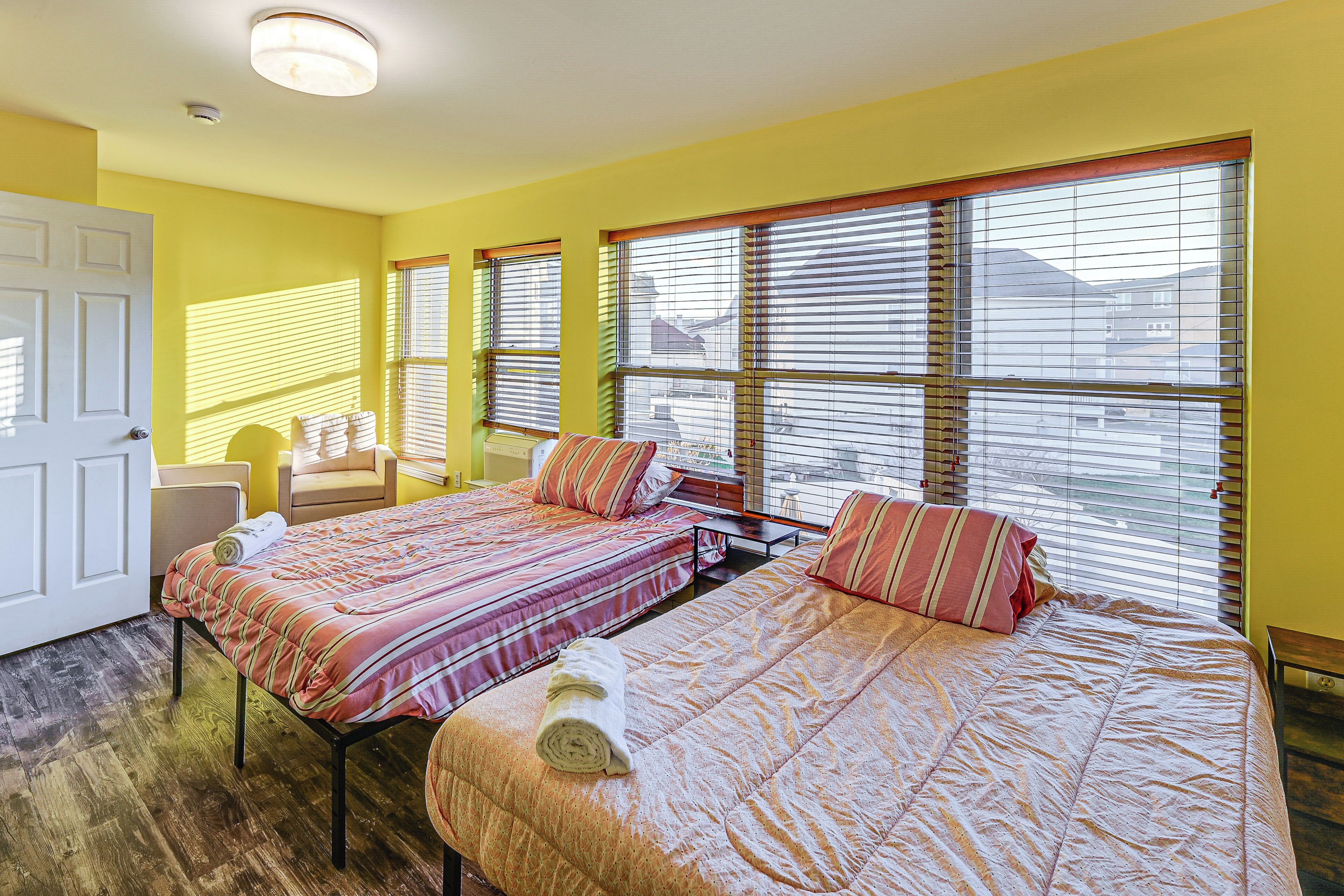 A room with two beds, a desk, and a chair.