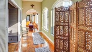 A hallway with wooden floors, a decorative door, and a bench. - Beachfront Living in Long Beach: 2,500 Sq Ft Condo (Long Beach)