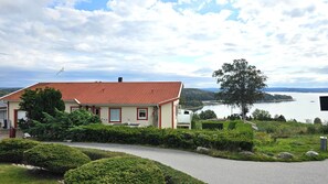 Ein Haus mit rotem Ziegeldach, einer Flagge und Blick auf einen See.
