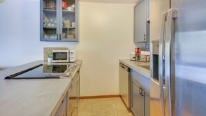 A modern kitchen with a microwave, stove, refrigerator, and cabinets. - Walk to Chair Lift: Mtn-view Schweitzer Studio! (Sandpoint)