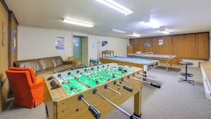 A room with a foosball table, a pool table, a sofa, and a ping pong table. - Walk to Chair Lift: Mtn-view Schweitzer Studio! (Sandpoint)