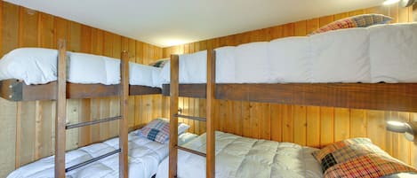 A bunk bed room with wooden walls and a ladder.
