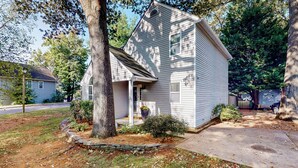 A small, single-story house with a front porch, surrounded by trees and a well-maintained lawn. - 3BR Dog-friendly Retreat w/ Fireplace & Patio (Annapolis)