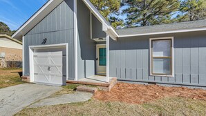 A two-story house with a garage, a front door, and a window. - Quiet & Modern Family Home in Spring Lake (Spring Lake)
