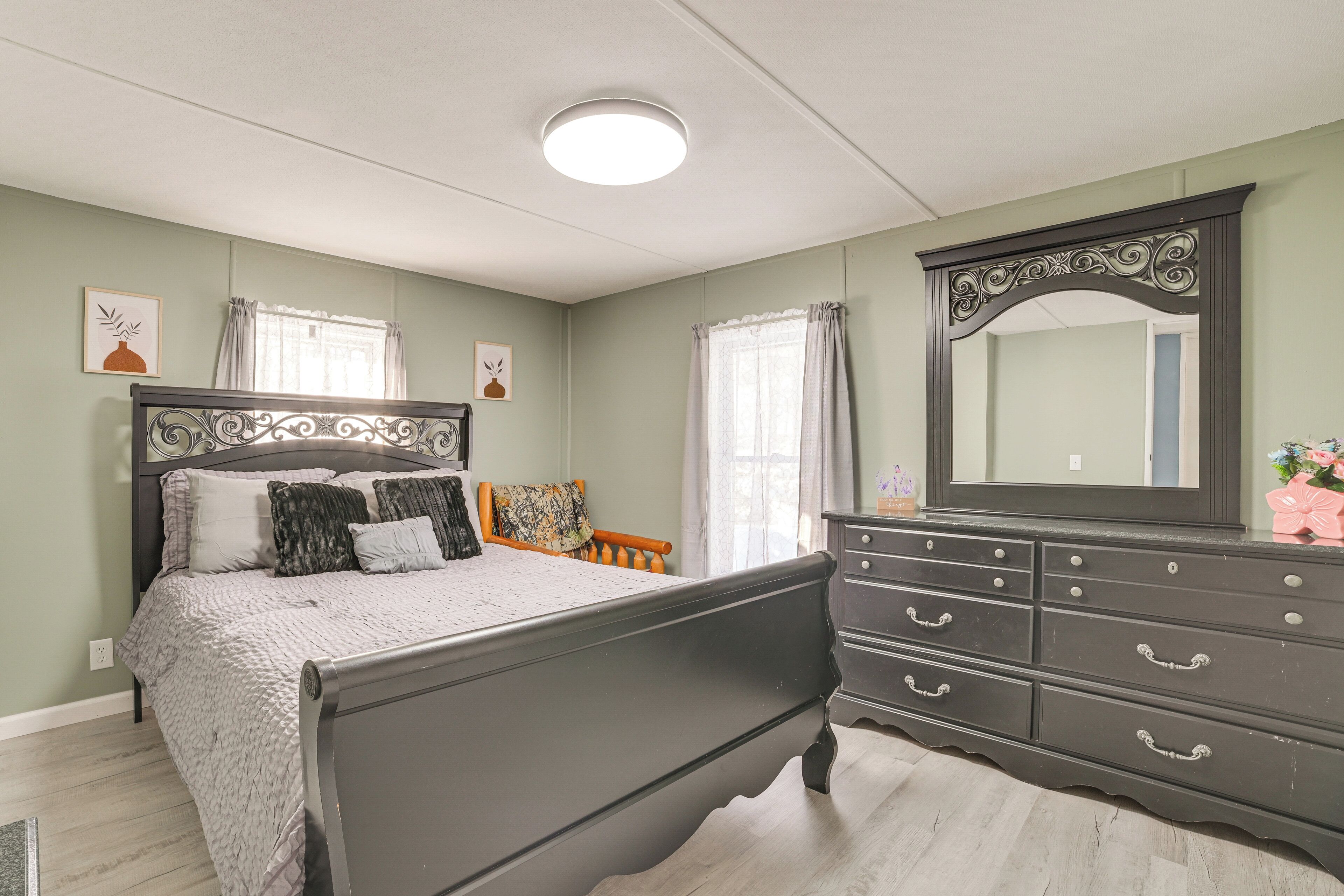 Une chambre à coucher avec un lit, une commode et un miroir.