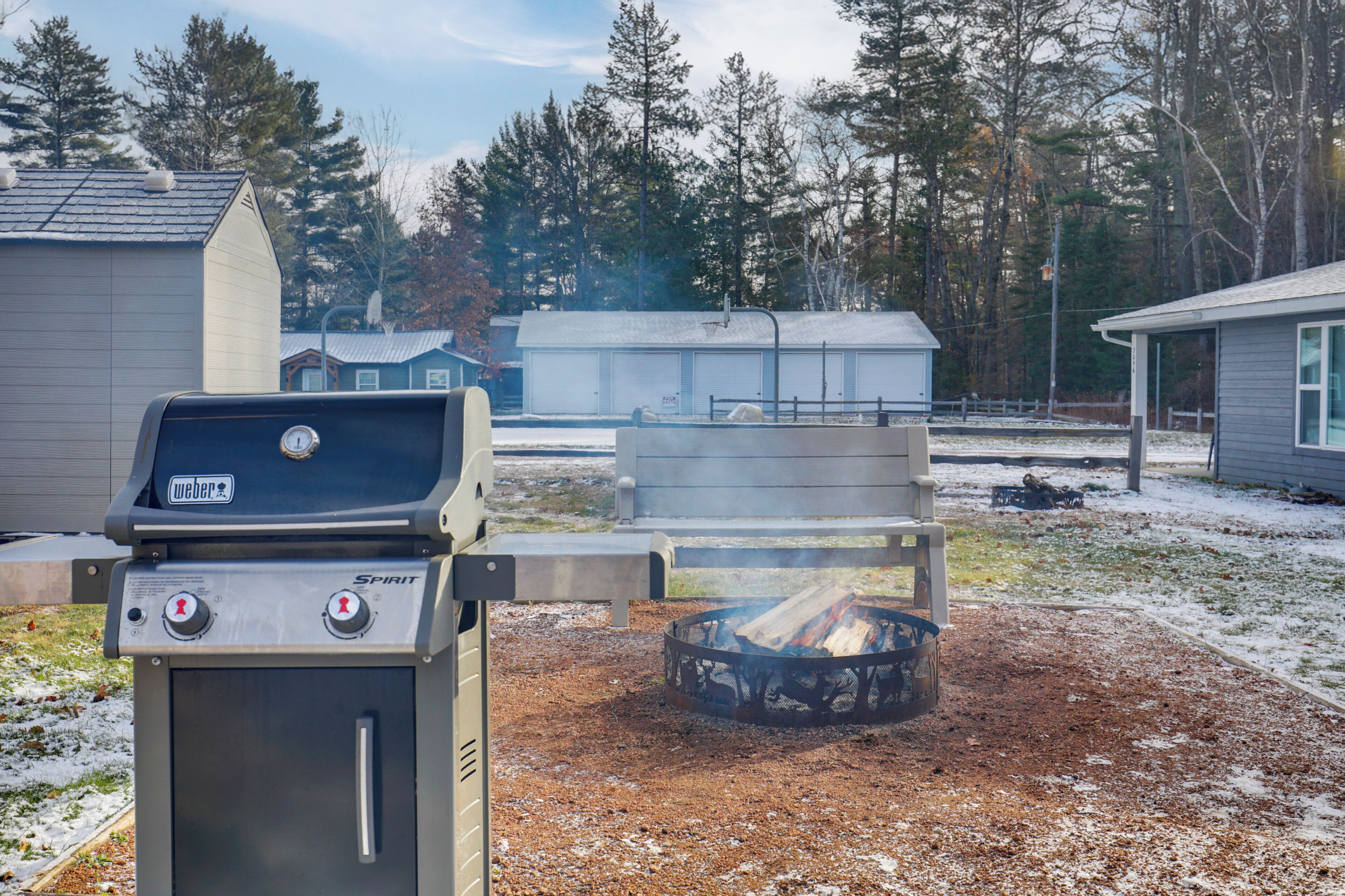 Weber Spirit -grilli ja sen yhteydessä oleva nuotiopaikka takapihalla.