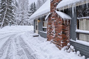 A snow-covered house with a brick chimney, a wooden door, and a window with a curtain. - 7 Mi to Mount Snow Cozy 4BR Mountain Retreat (West Dover)