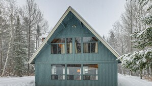 A two-story wooden cabin with a steep gable roof, surrounded by snow-covered trees. - Outdoor Adventure Hub! Family Home in West Dover (West Dover)