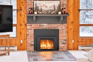 A fireplace with a fire, a mounted television, and a framed picture above it. - 7 Mi to Mount Snow Cozy 4BR Mountain Retreat (West Dover)