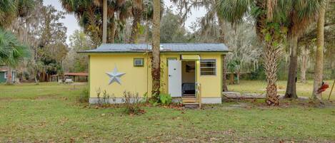 A small, yellow building with a star decoration, a door, and a small porch area.