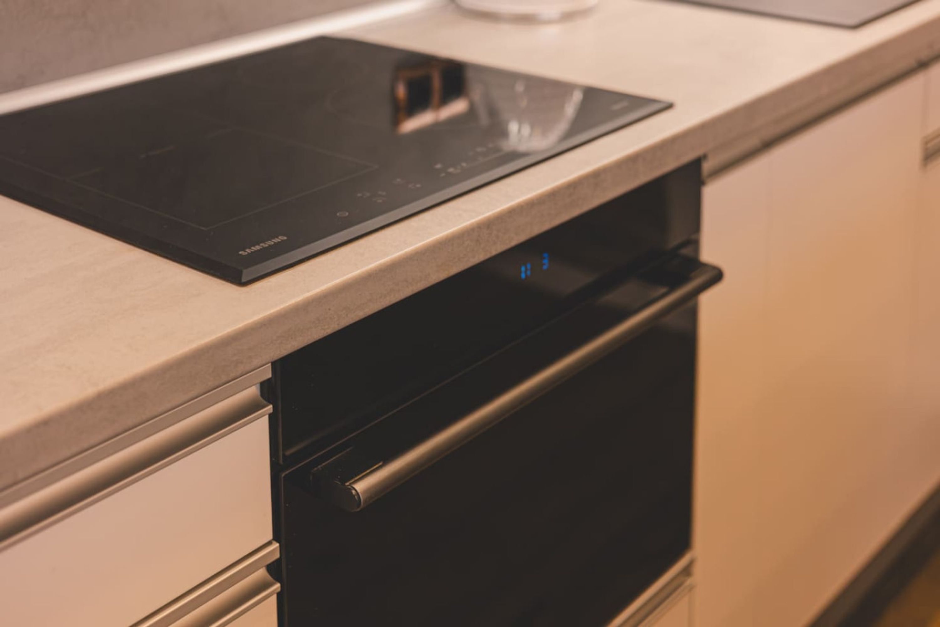 Una cucina con piano cottura a induzione integrato e forno in acciaio inossidabile.
