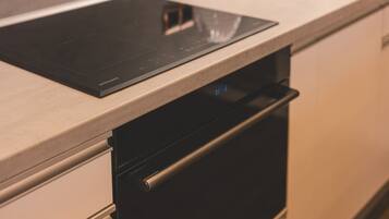 Una cucina con piano cottura a induzione integrato e forno in acciaio inossidabile.