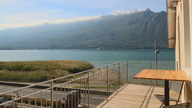 A balcony with a view of a lake and mountains.