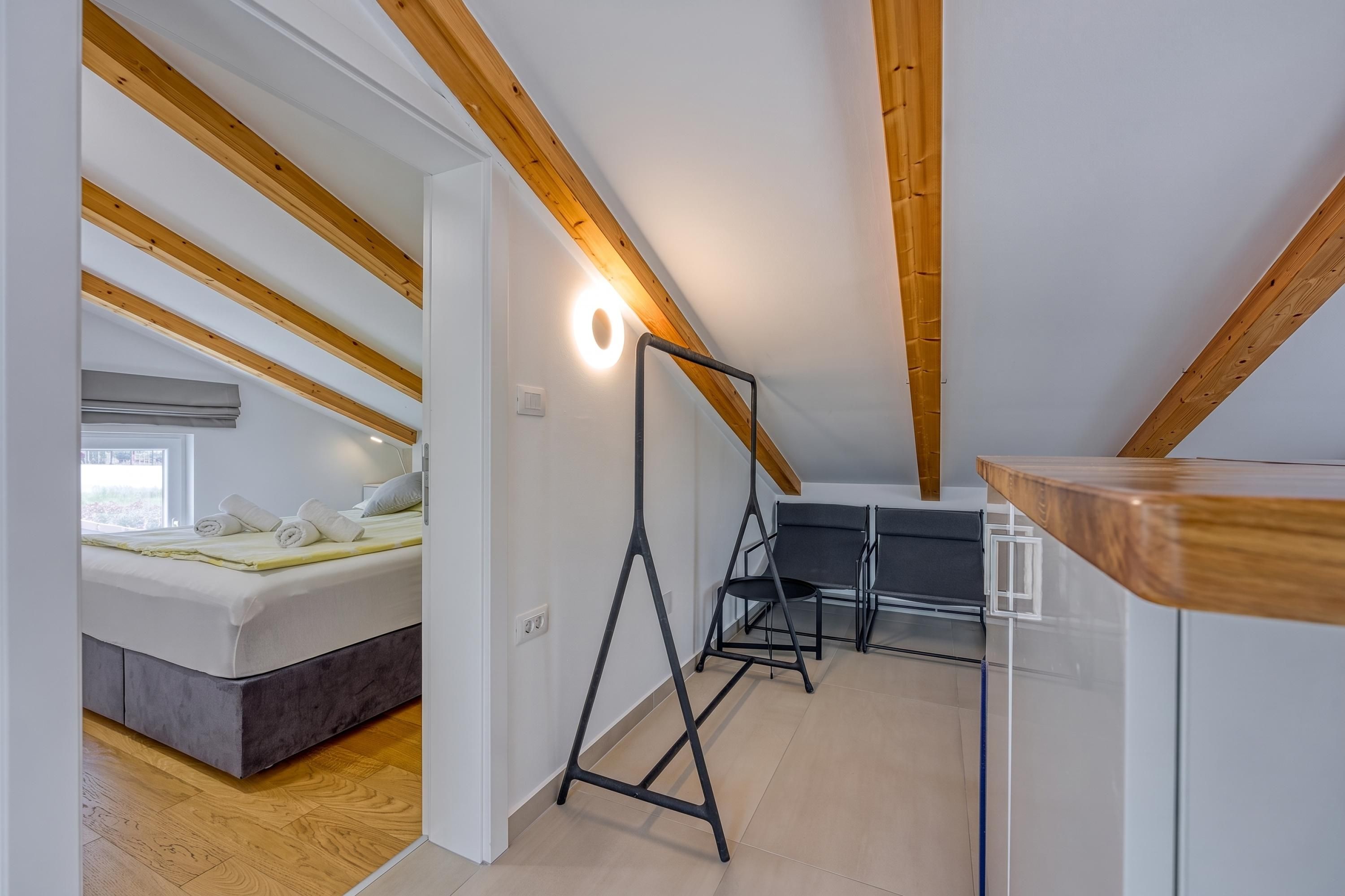 Een slaapkamer met een bed, een bureau en een stoel.