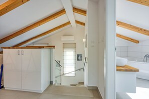 Een moderne keuken met witte kasten, een houten aanrechtblad en een inbouwoven.