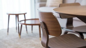 Uma sala de jantar moderna com uma mesa redonda e cadeiras de madeira.