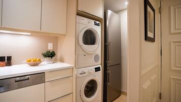 A compact kitchen with a dishwasher, a washing machine, and a refrigerator.