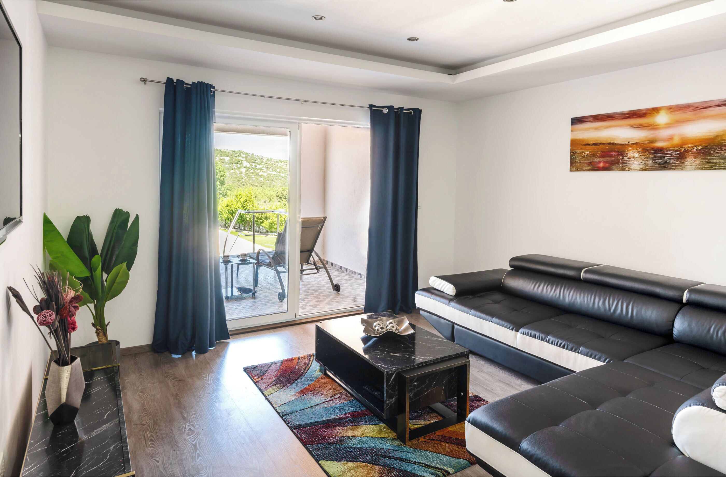 Een moderne woonkamer met een bank, een salontafel en uitzicht op de omgeving.