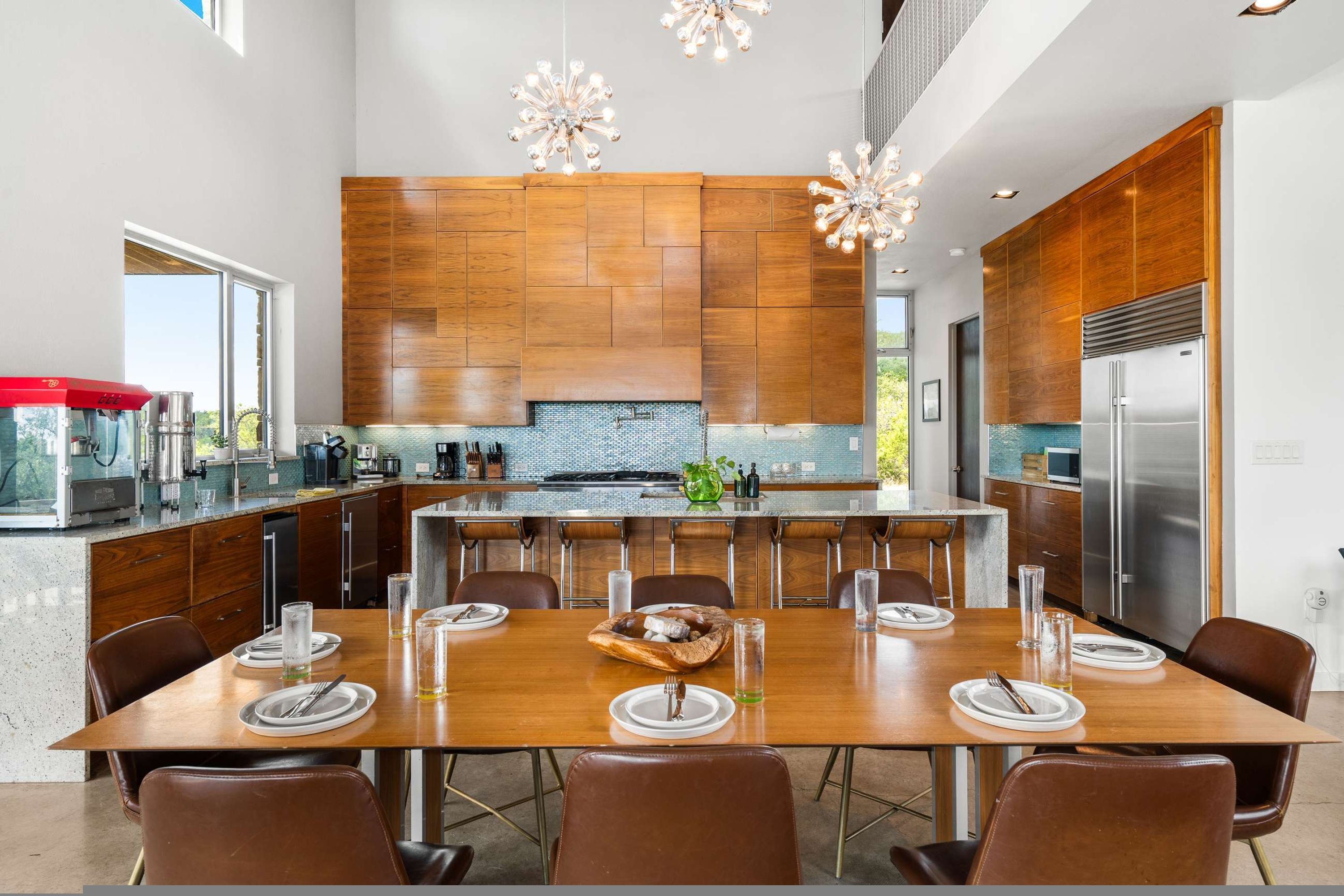 A modern kitchen with wooden cabinetry, a large island, and stainless steel appliances.