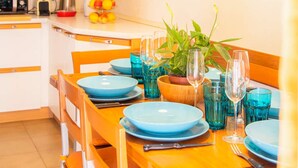 A dining area with a wooden table set for four, blue plates, and a potted plant. - Casa Romitino Modern and Spacious Apartment (Florence)