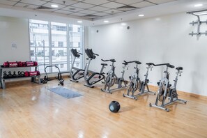 A gym with stationary bikes, kettlebells, and a medicine ball. - Stayshort - Modern 1 Bedroom Getaway Sleeps 4 in Dubai Marina (Dubai)