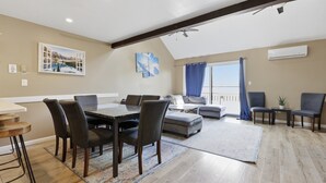 A spacious living area with a dining table, chairs, a sofa, and a balcony with a view. - Pocono Paradise Ultimate Camelback Getaway 4 Bedroom Townhouse (Tannersville)