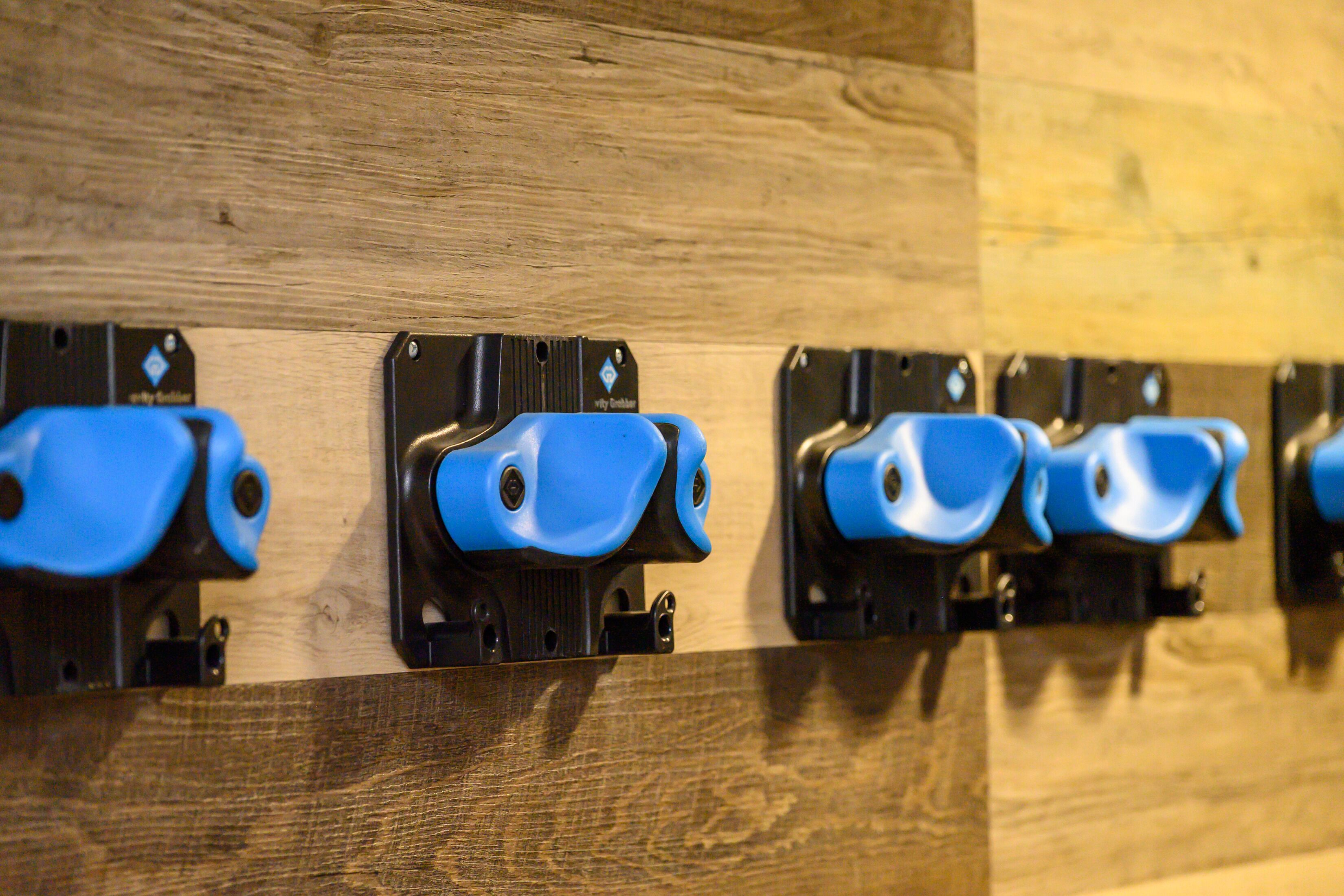 A row of blue handrails attached to a wooden wall.