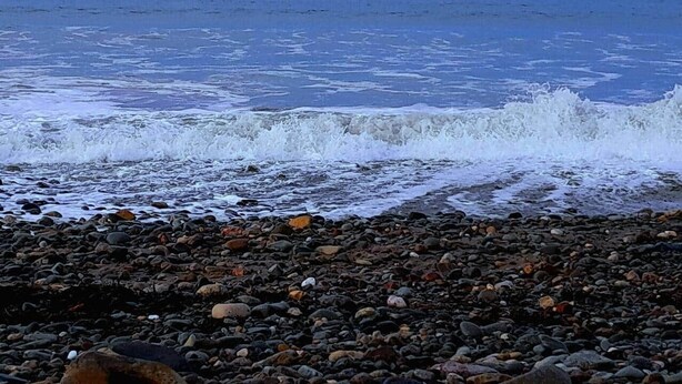 A rocky beach with waves crashing onto the shore.