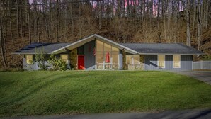 Ein eingeschossiges Haus mit Satteldach, einer Veranda und einem kleinen Vorgarten.