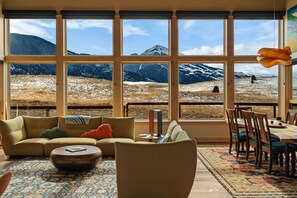 Un accogliente soggiorno con una grande finestra che si affaccia su una vista montana.