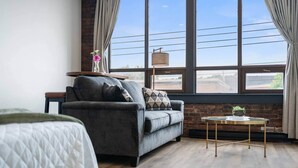 A modern room with a grey sofa, a small round table, and a bed.