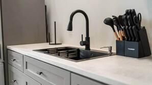A modern kitchen with a black faucet, a knife block, and a built-in sink.
