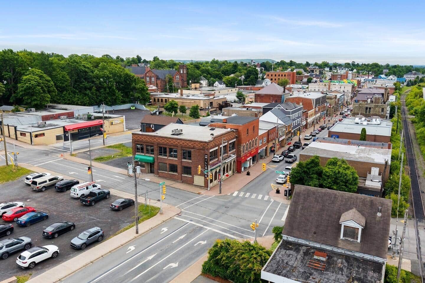 A downtown street with buildings, cars, and a pedestrian crossing.