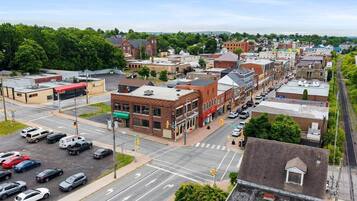 A downtown street with buildings, cars, and a pedestrian crossing.