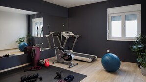 A gym with exercise equipment, a treadmill, and a large blue exercise ball. - Villa Peregrine (Pakostane)