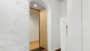A hallway with white walls, wooden flooring, and an arched doorway leading to another room. - The Cocon Room with Wi-Fi (Frossay)