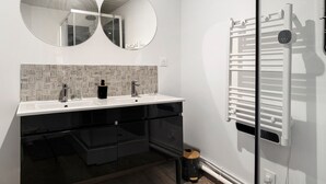 A modern bathroom with two sinks, a mirror, and a towel rack. - The Cocon Room with Wi-Fi (Frossay)