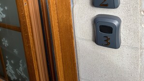 A door with a wooden frame and a textured wall with three numbered mail slots. - “Beehive Nest” Room with Wi-Fi (Frossay)