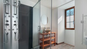 A modern bathroom with a glass shower enclosure, a wooden vanity, and a window providing natural light. - La Bohème Room 3 with Wi-Fi (Frossay)