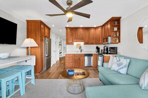 A modern kitchen with wooden cabinets, a built-in oven, and a ceiling fan. - Sea Side Villas 258| | Beach View | Private Pool | Near Coligny & Sea Pines (Hilton Head Island)