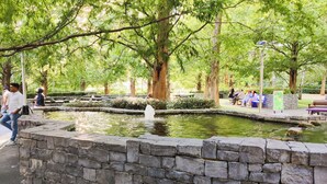A stone wall with a pond and a fountain in a park. - Stylish & Comfy | Near Canary Wharf | Self Check-In | WiFi (London)