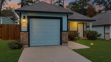 A residential house with a garage, a front yard, and a wooden fence.