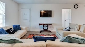 A living room with two sofas, a TV, and a small table. - Docked at Lake Conroe in Willis | Extended Stays (Willis)