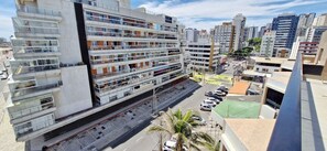 A multi-story building with balconies, a parking lot, and a street view. - COPIT0108 - Condomínio Pituba Sol (Salvador)