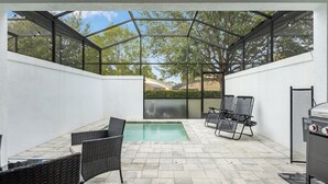 Patio esterno con piscina, area relax e barbecue.