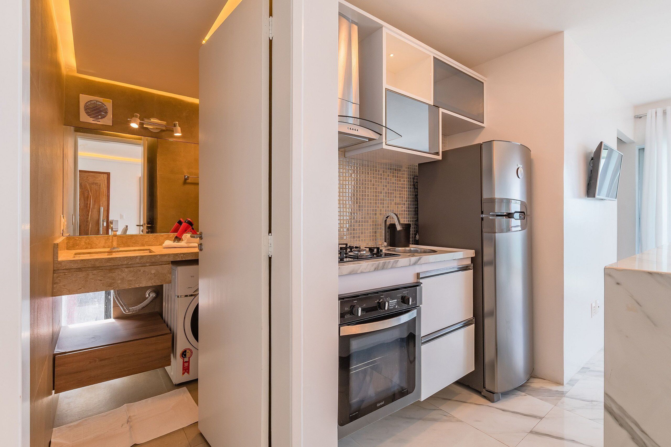Una cocina moderna con horno integrado, refrigerador y pileta.