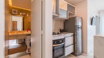 Una cocina moderna con horno integrado, refrigerador y pileta.